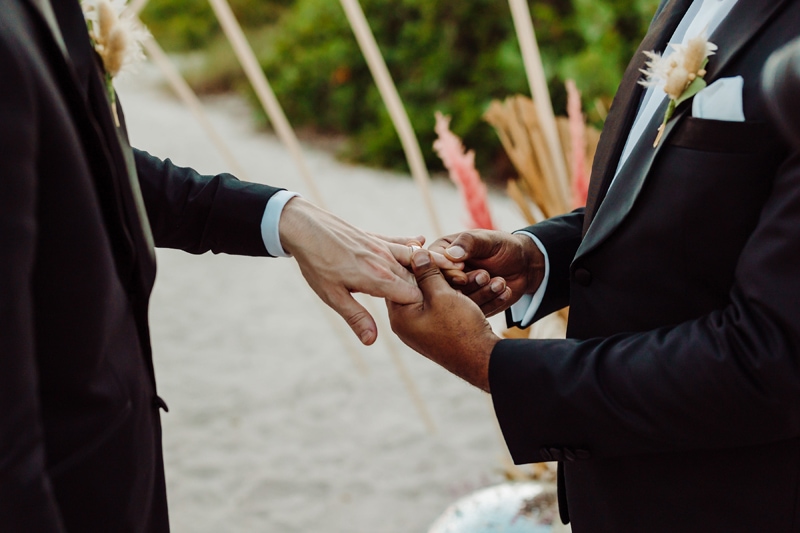 Elopement Photographer, a man places a ring on his partner's hand during the wedding ceremony